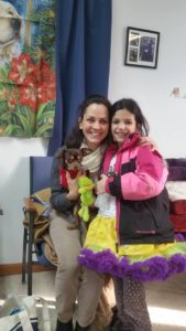 A small girl and a woman holding a dog