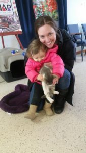 A woman with her daughter holding a cat