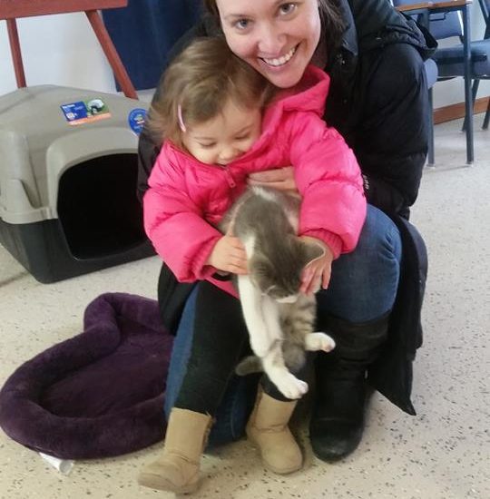 A woman with her daughter holding a cat