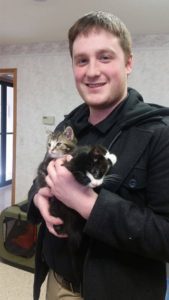 A man holding two kittens.