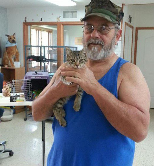 A man holding a cat in a room.