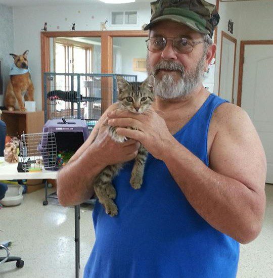 A man holding a cat in a room.