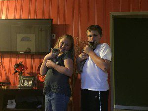 A boy and a girl standing in front of a tv.