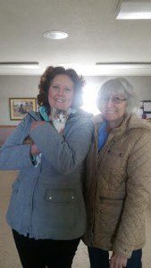 Two elder woman holding a kitten