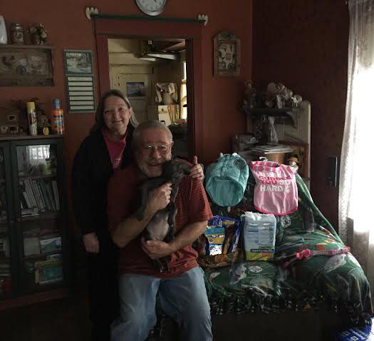 A man and woman posing in a room with a lot of items.