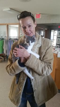 A woman holding a cat in a store.