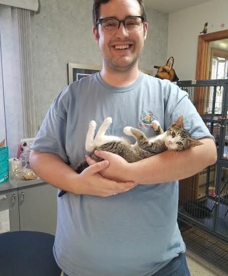 A man holding a cat in his arms.